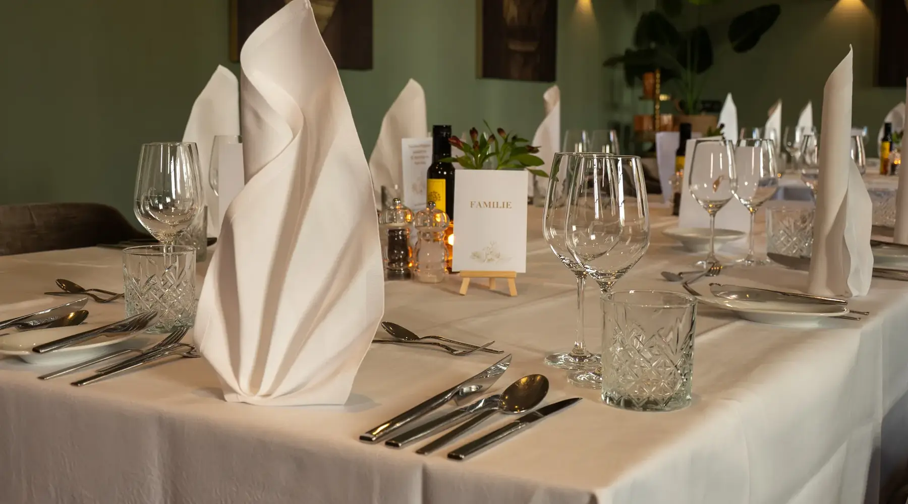 Detailaufnahme einer festlich gedeckten Tafel mit weißen Stoffservietten, Gläsern und Besteck im Van der Valk Hotel Hildesheim.