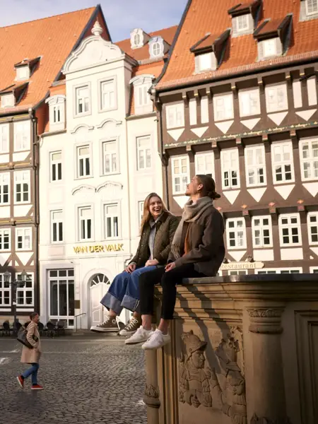 Mann und Frau am Rand eines Brunnens im Zentrum von Hildesheim