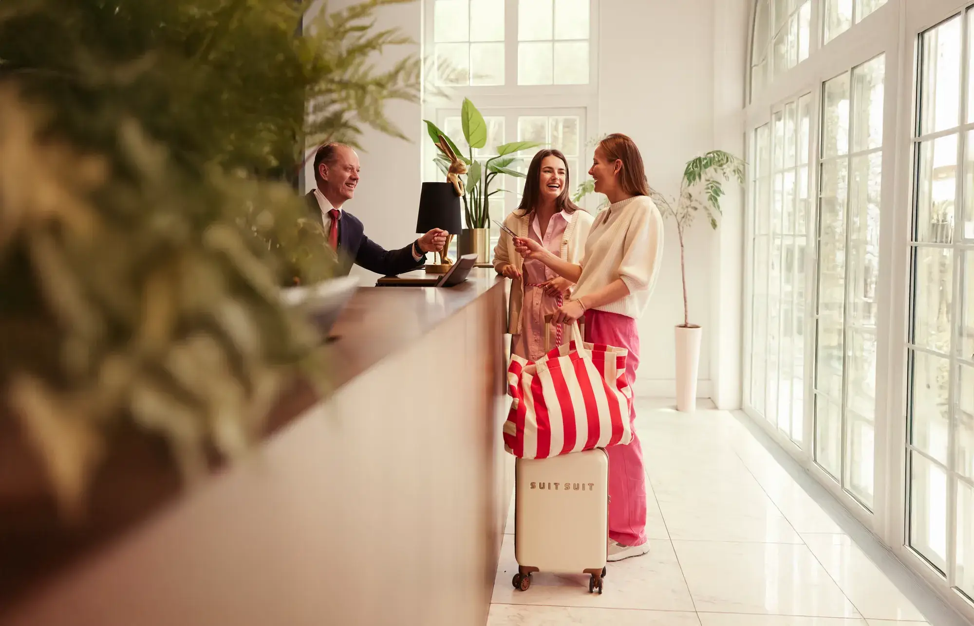 Vriendinnen checken in bij de receptie van een hotel