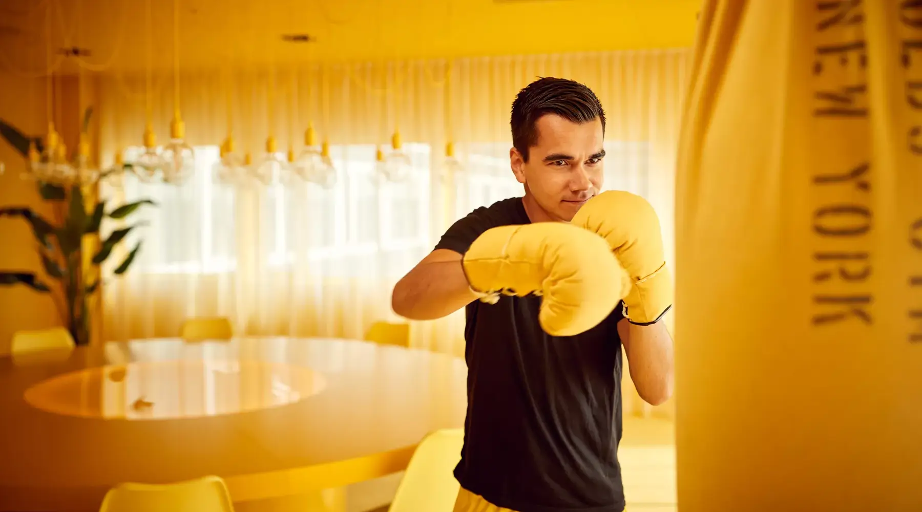 Man with boxing gloves in yellow room