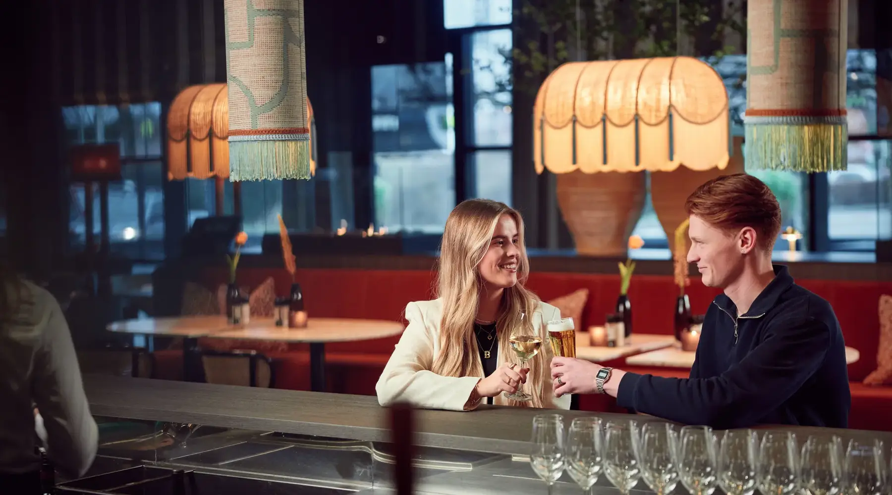 Twee mensen aan een bar die proosten