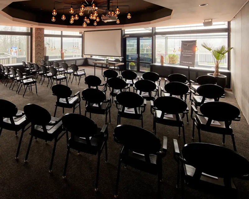 Salle de réunion avec de longues tables et des chaises