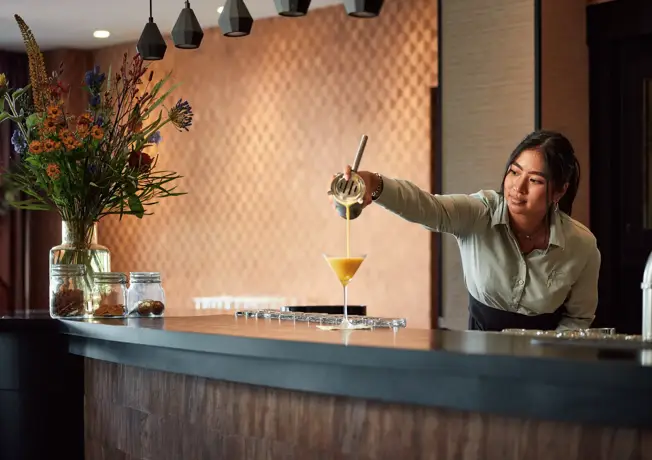 Mädchen, das ein Getränk einschenkt.