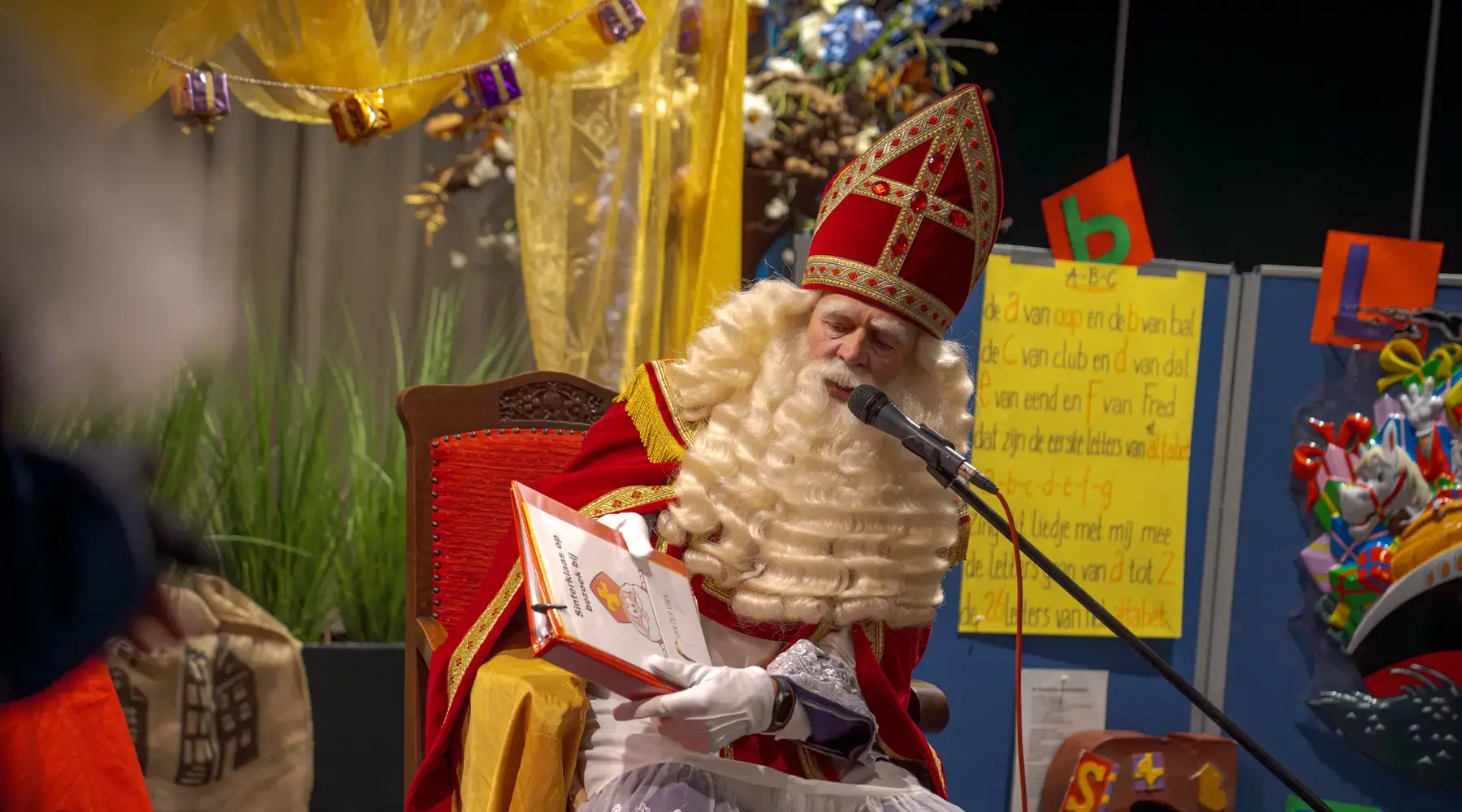 Sinterklaas leest voor uit het grote boek tijdens de Sinterklaasshow bij Van der Vak Hotel Hoorn