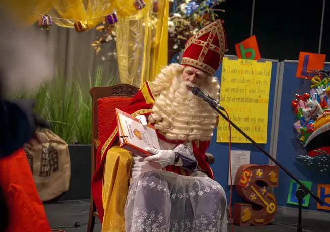 Sinterklaas leest voor uit het grote boek tijdens de Sinterklaasshow bij Van der Vak Hotel Hoorn