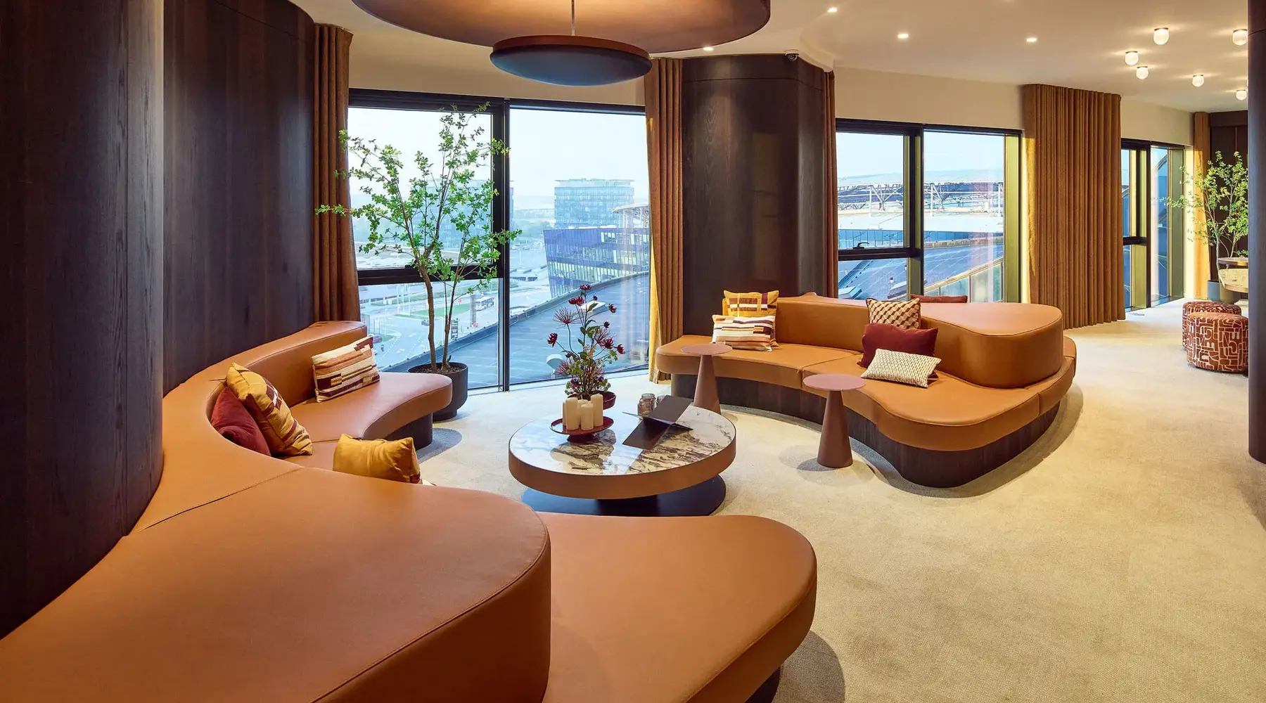Ruimte nabij de vergaderzalen vanHotel Gent. Met moderne oranje banken en uitzicht.