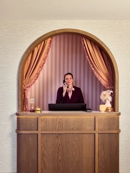 Receptionist aan de telefoon in een Van der Valk hotel