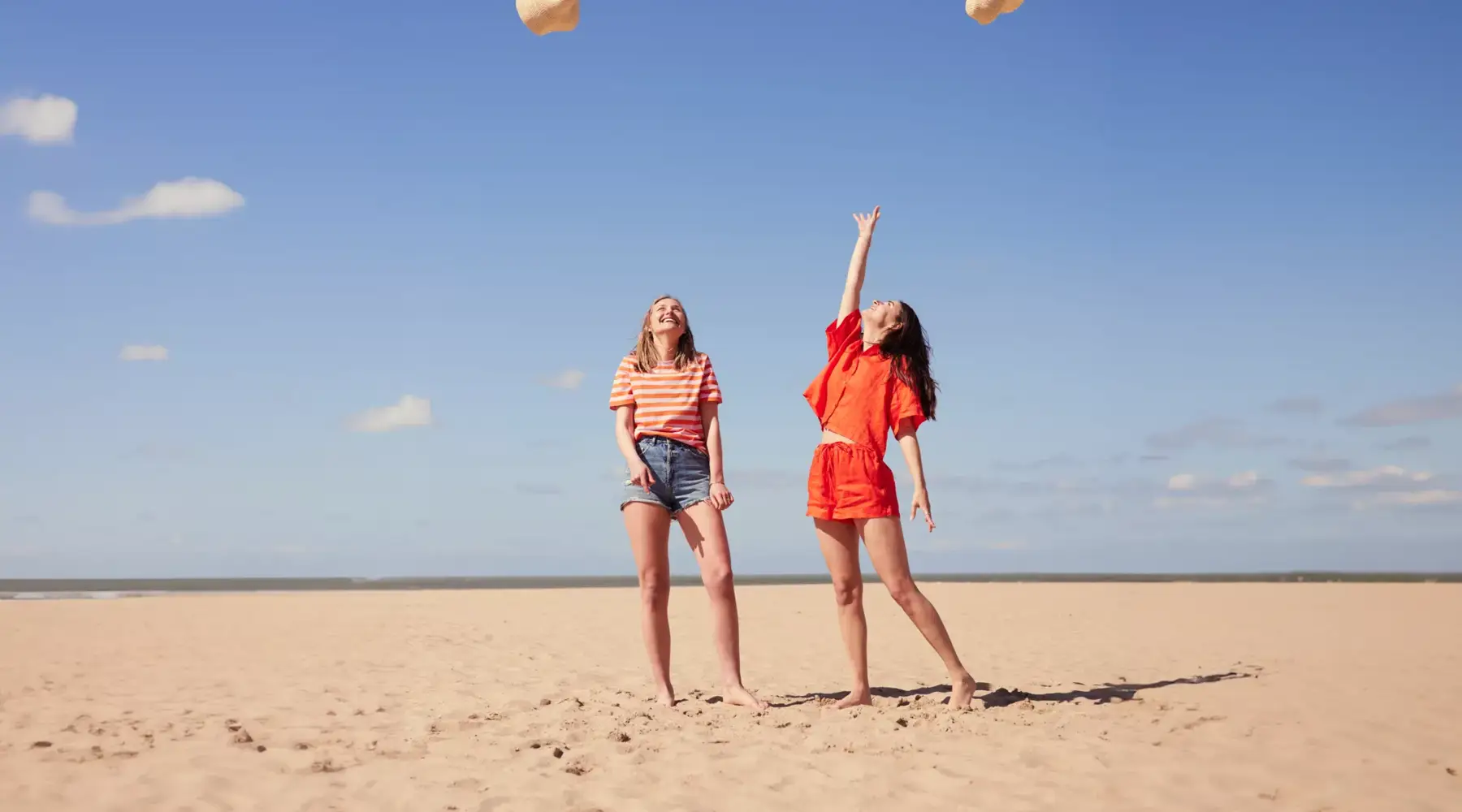 Two women on beach chairs in the sun on the beach in Bruges.