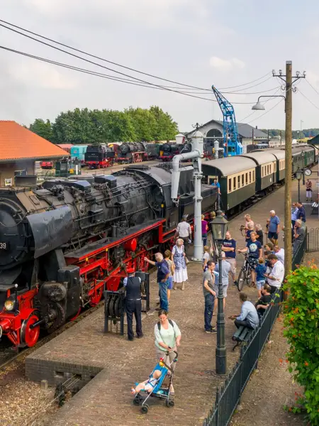 Steam train on the platform with red and black details