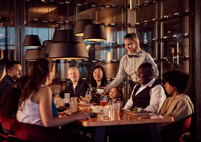 serveerster aan tafel bij groep mensen