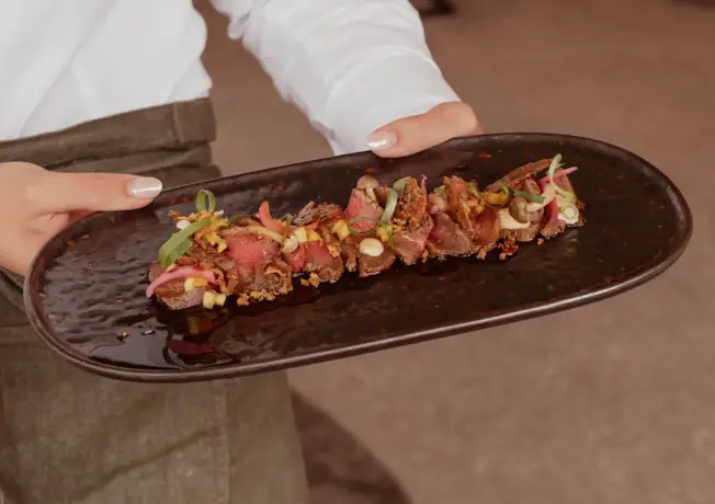 Foto van personeel die de Beef Tataki vasthoudt