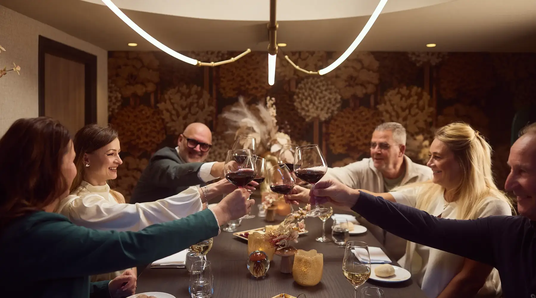 Business meeting. Group of people toasting with glasses at a set table.