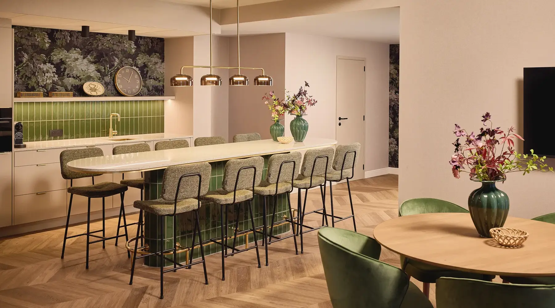 Salle dans l'hôtel Paris. Grande table ovale en bois avec des chaises blanches autour. 2 écrans sur le mur.