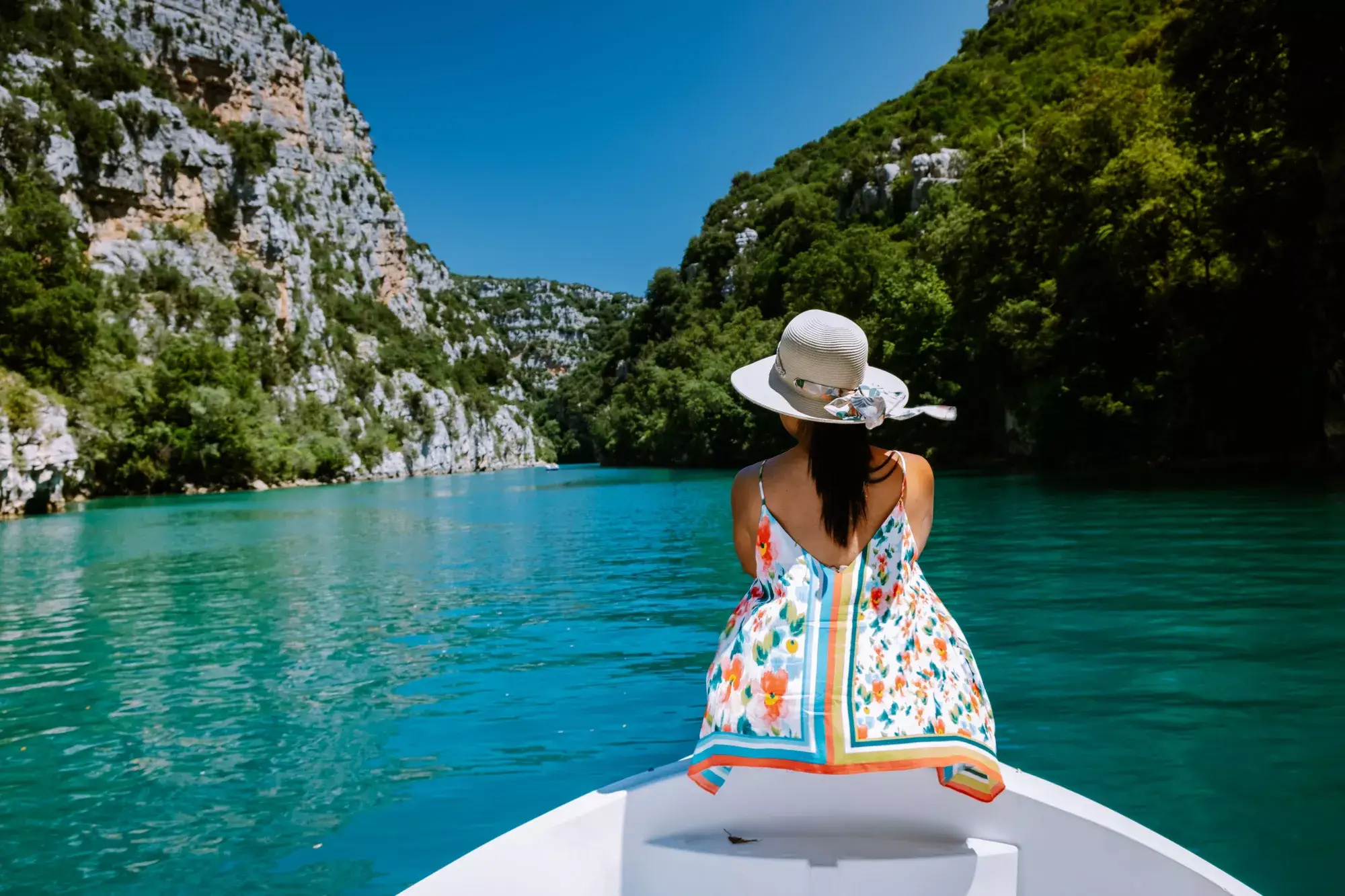 Une dame est assise sur la pointe d'un bateau dans les Gorges du Verdon