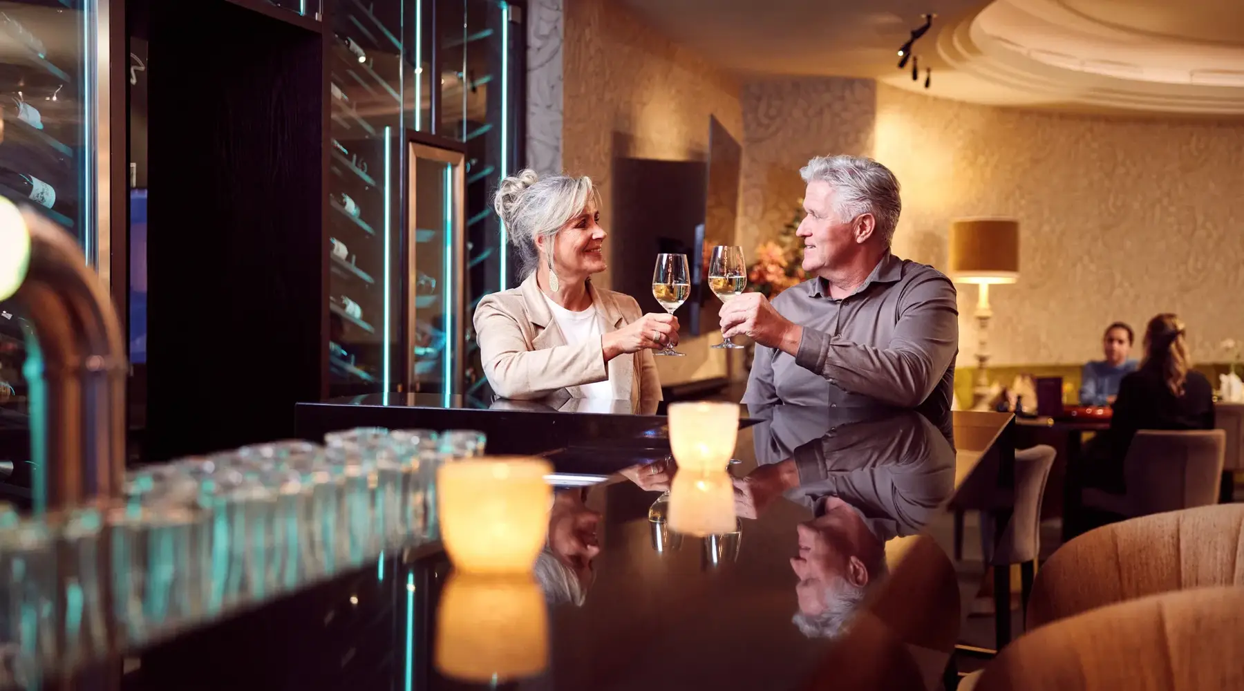 Older couple toasts at the bar in a Van der Valk hotel
