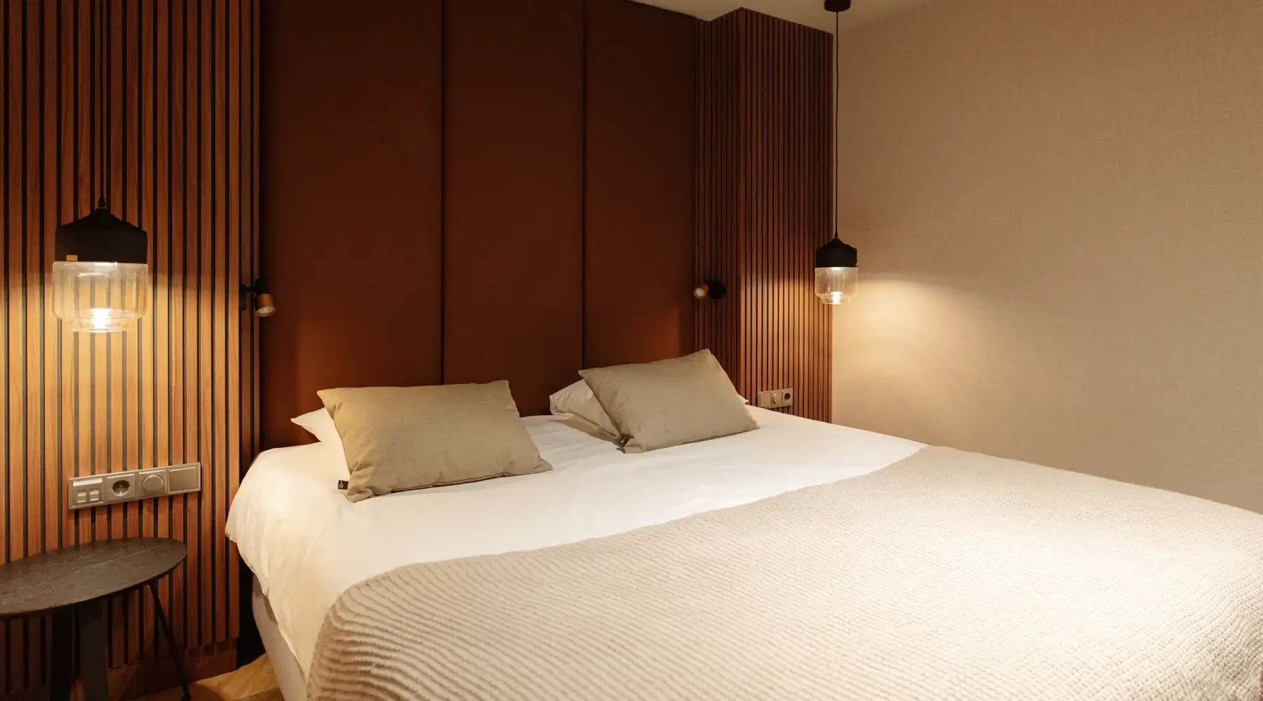 Sfeervolle hotelkamer met verlichting en beige bedlinnen