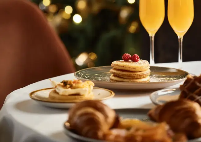 Stimmungsvoll gedeckter Tisch für das Weihnachtsessen mit Kerzenlicht und festlicher Dekoration.