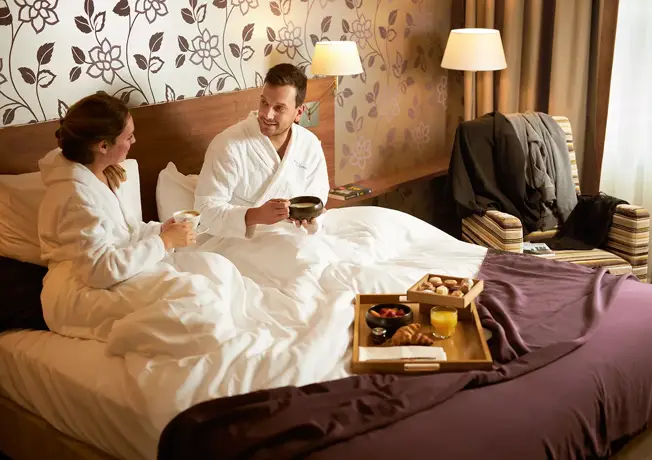 een stel samen op bed met een ontbijtje