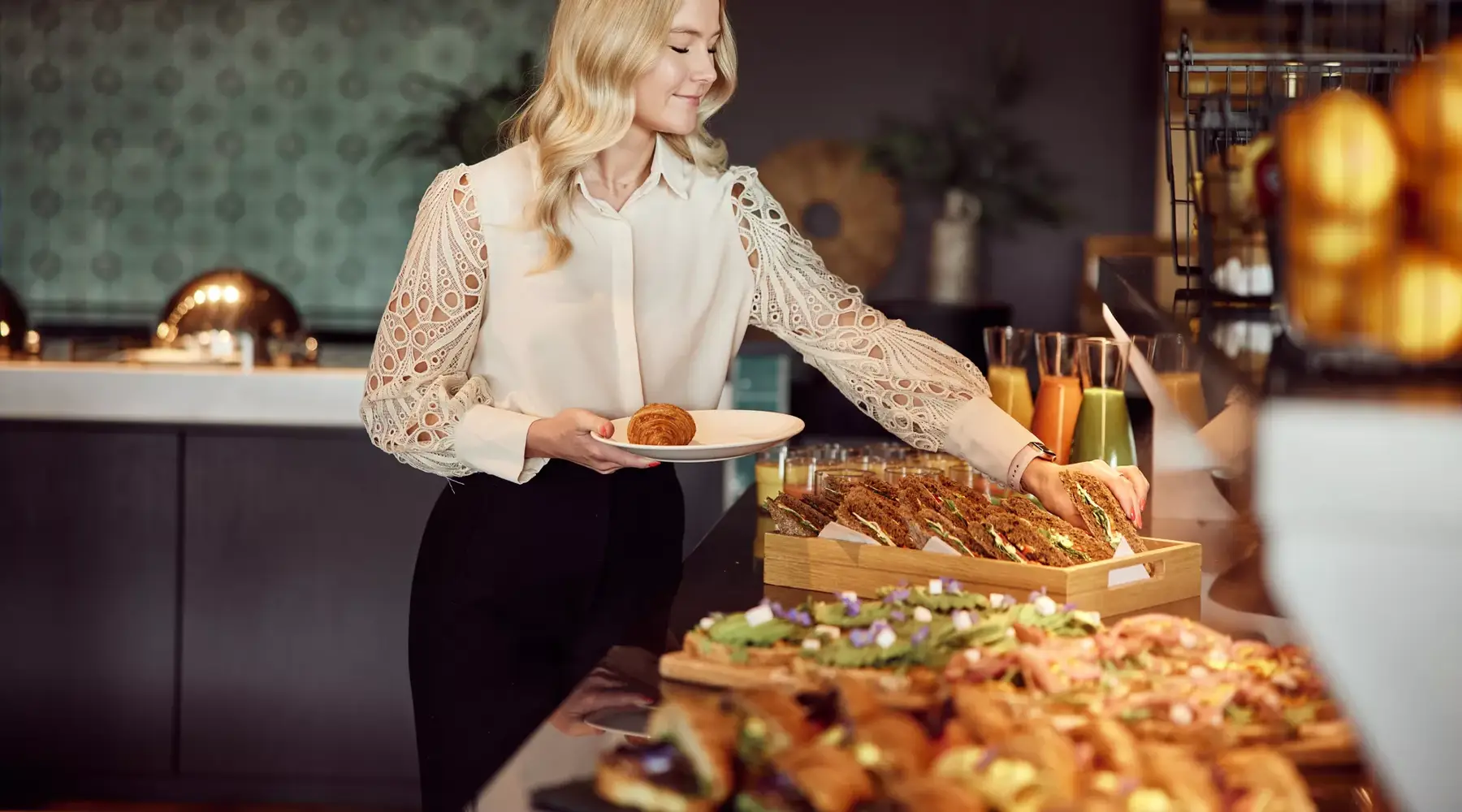 Vrouw pakt broodje van brunchbuffet