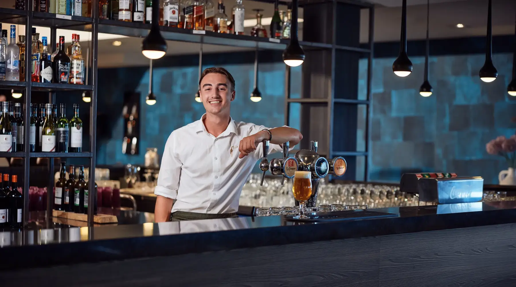 Zwei Personen an einer Bar, die anstoßen.