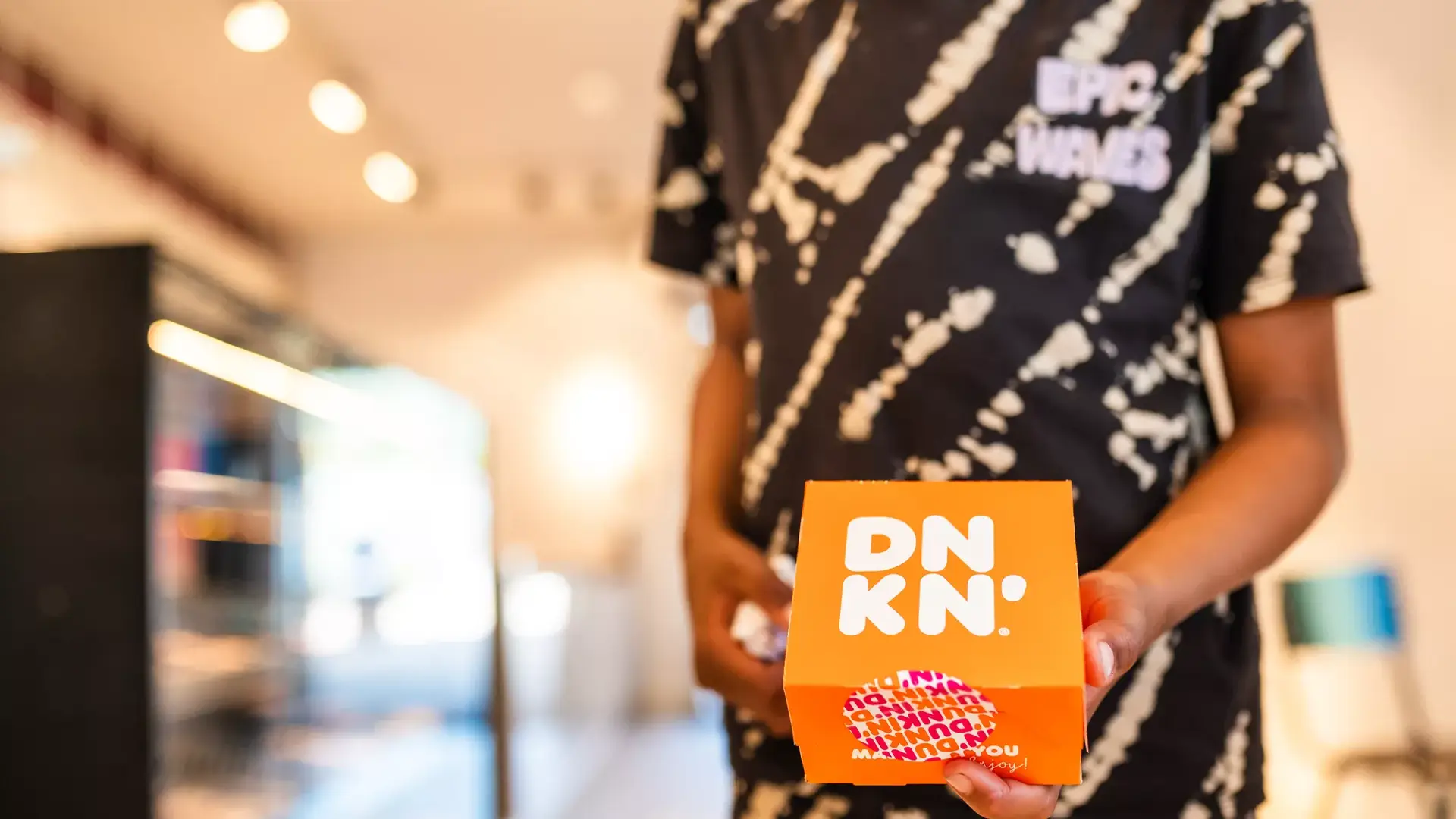Kind met doos Dunkin in de shop