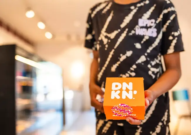 Kind met doos Dunkin in de shop