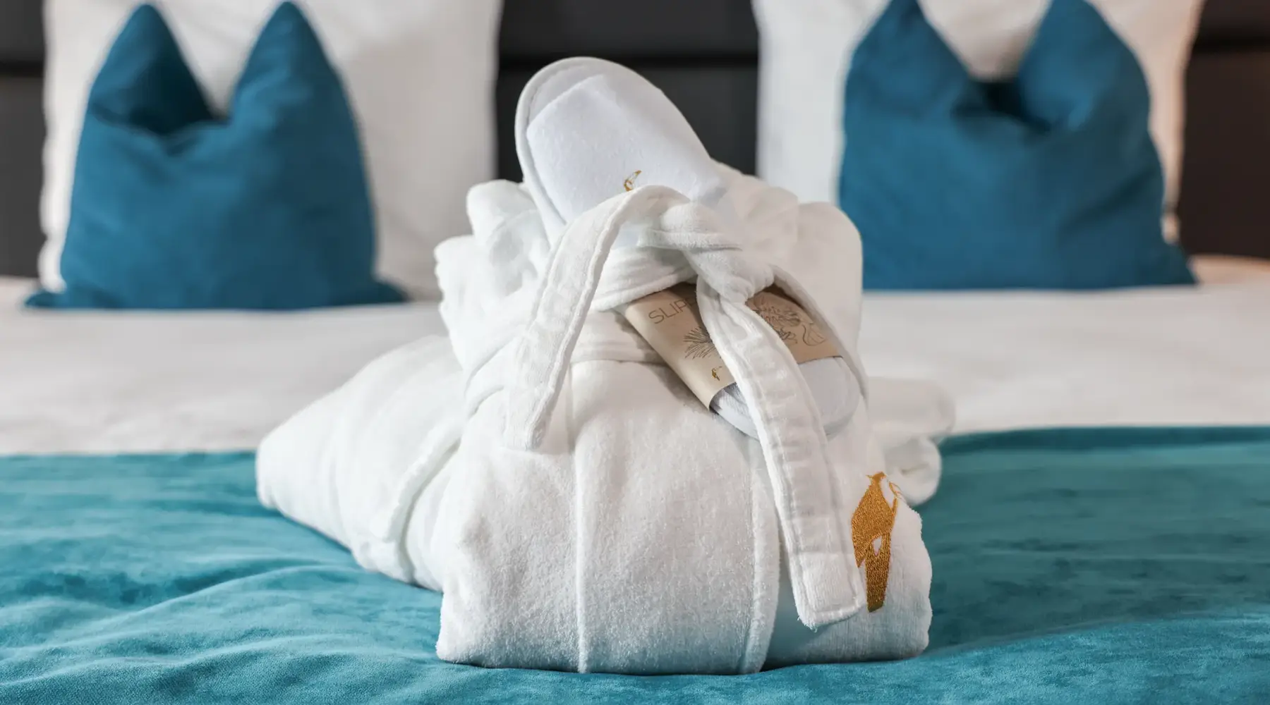 Badjassen en slippers op het bed in een Executive kamer van Van der Valk Hotel Hoorn.