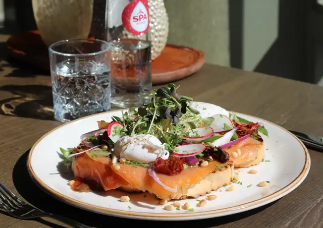 Foto van de YUMI Toast; toast met gerookte zalm, avocado en gepocheerd ei