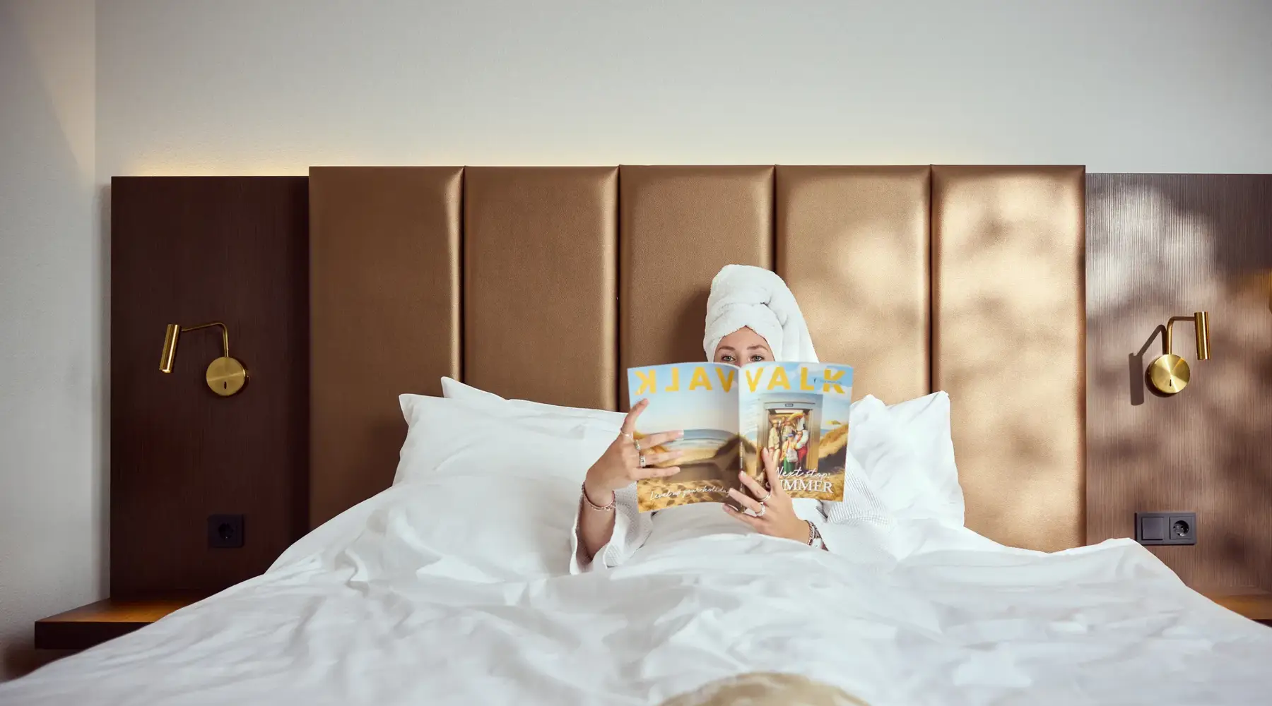 Woman in bed reading Valk Magazine