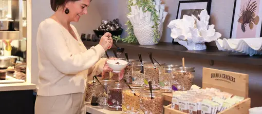 Eine Frau schöpft sich Cruesli für ihren Joghurt am Buffet des Restaurants Vloed.
