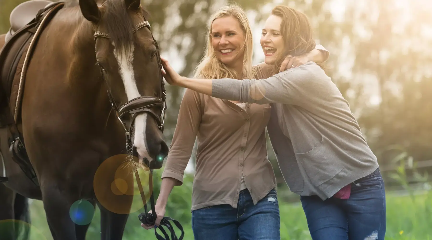 Zwei Frauen bei einem Pferd auf der Wiese.