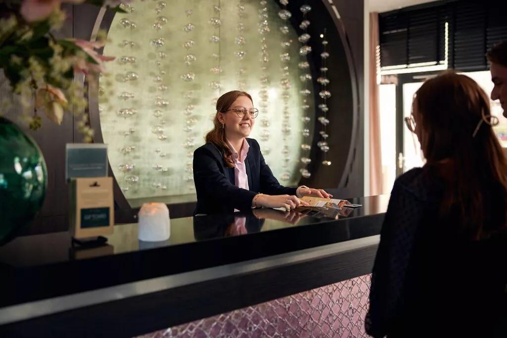 Mensen checken in bij de receptie van een hotel