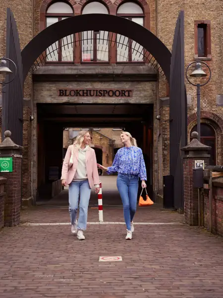 2 friends walk under the Blokhuispoort of Leeuwarden