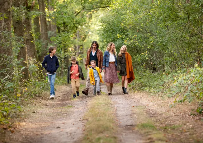 een gezin die door het bos loopt