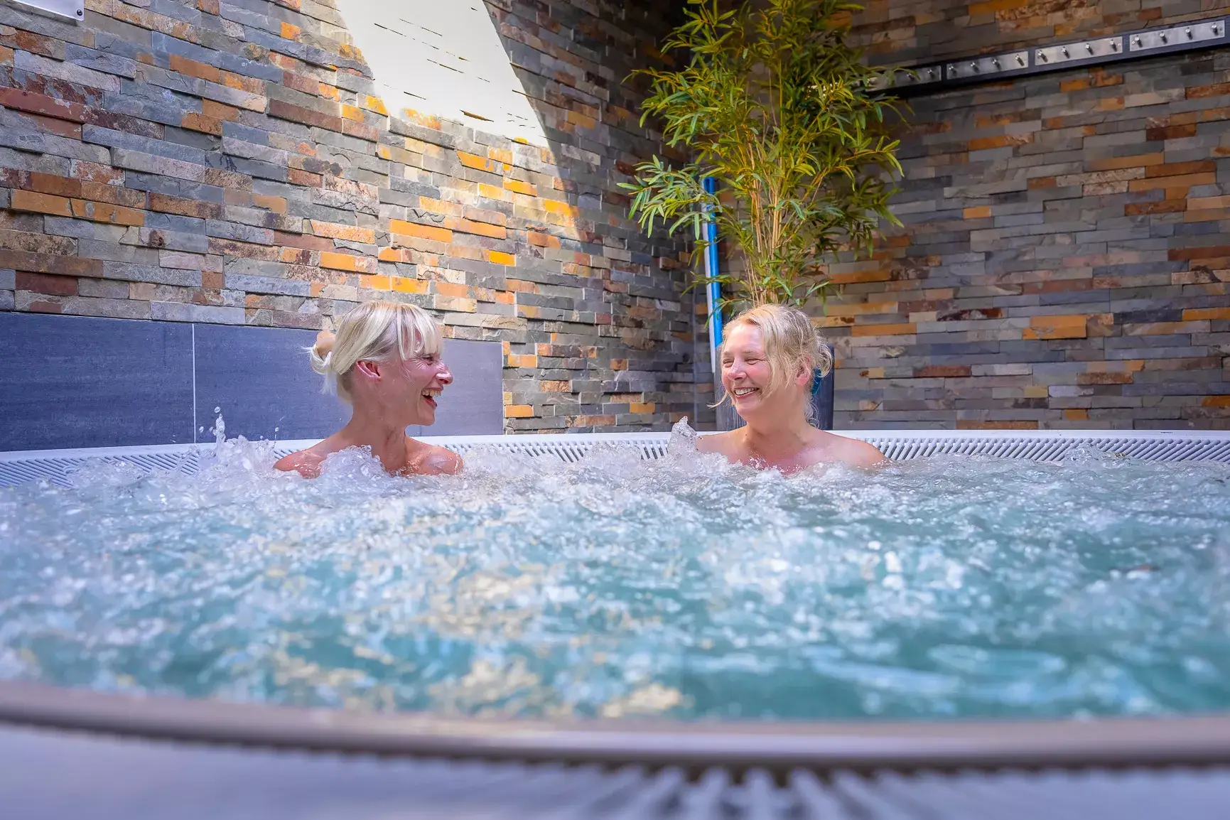 Deux personnes se relaxant dans le jacuzzi de l'hôtel Van der Valk Nivelles-Sud, ambiance détente et bien-être.