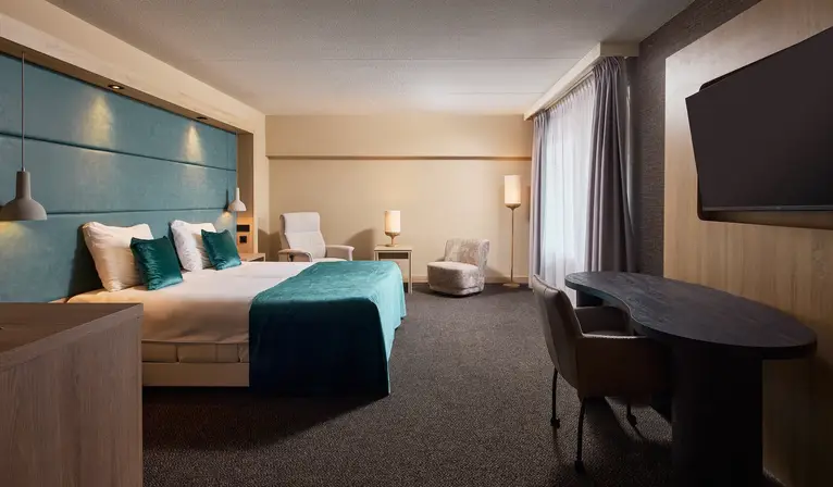Ruime comfort hotelkamer met tweepersoonsbed, zithoek en moderne inrichting in Van der Valk Hotel Leusden-Amersfoort