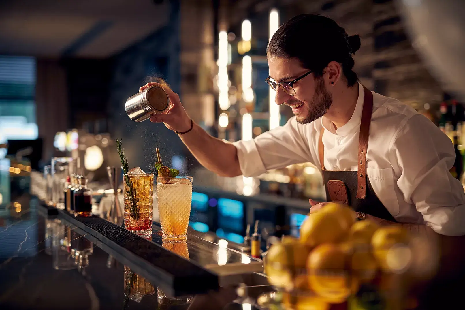 Barman expert préparant des cocktails au comptoir du bar lounge de l'hôtel Van der Valk Nivelles-Sud.