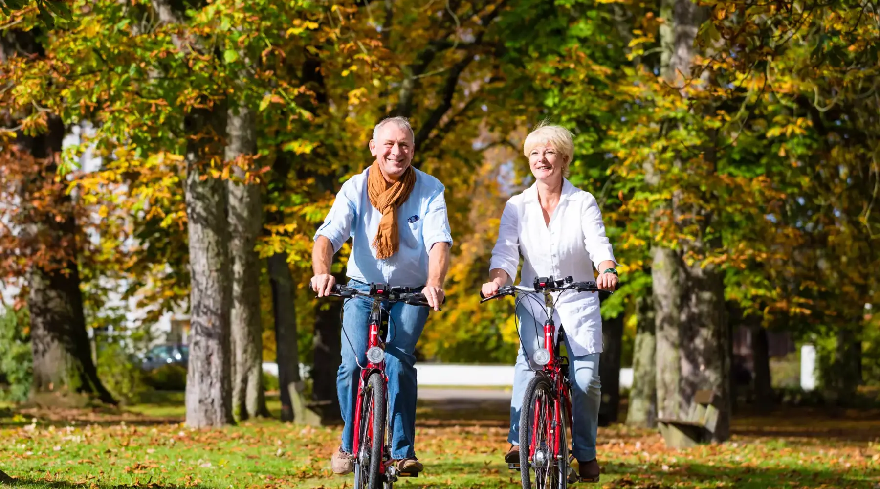 A man and a woman cycling through nature.