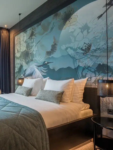 Luxury hotel suite with a king-size bed and blue colors.
