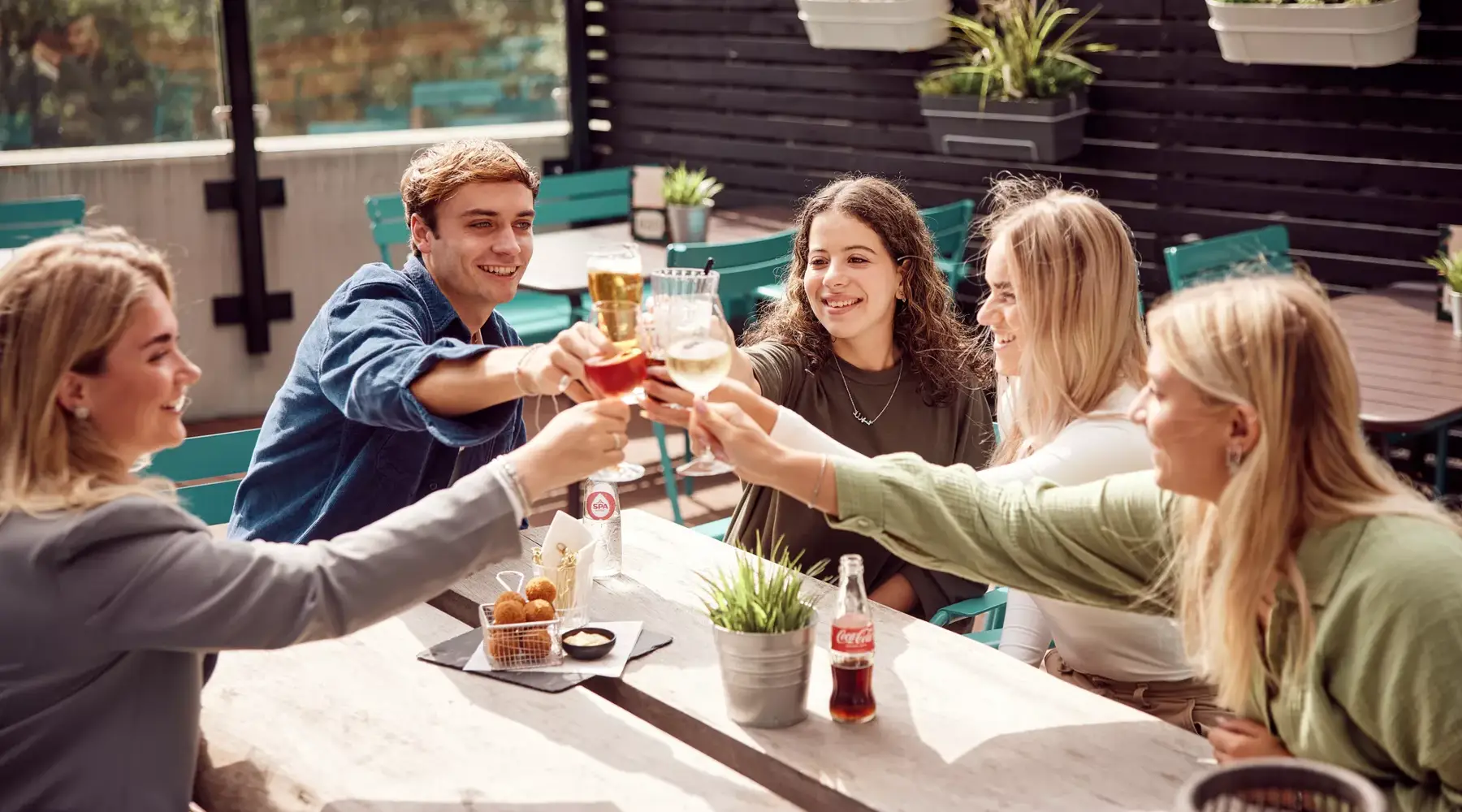 Groep vrienden proosten op het terras