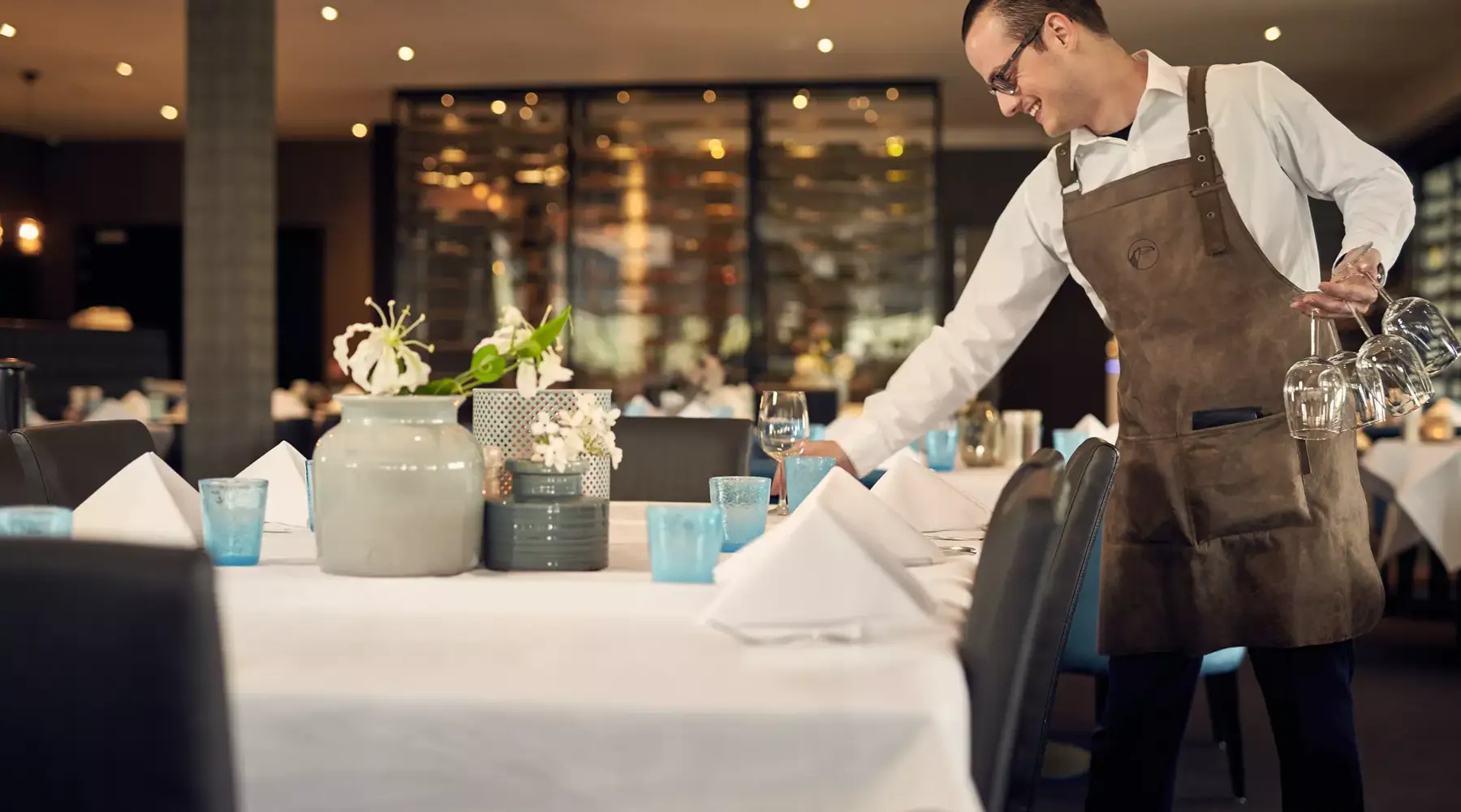 Ober dekt de tafels in het restaurant
