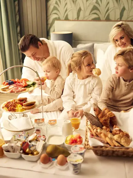 Familie im Bett mit Zimmerservice 