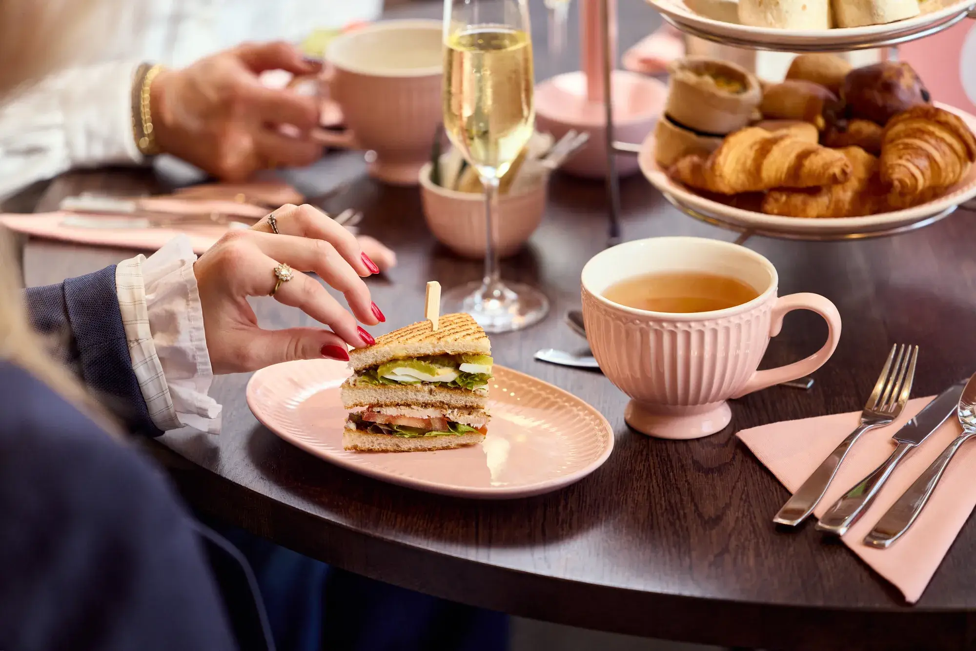 Woman grabs a sandwich during the High Tea by Toos