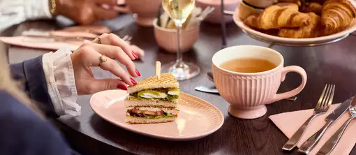 Woman grabs a sandwich during the High Tea by Toos