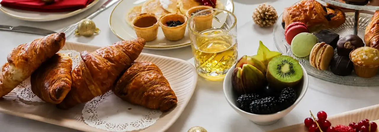 Reichhaltiger Weihnachtsbrunch mit warmen und kalten Speisen, süßen Leckereien und festlicher Weihnachtsdekoration.