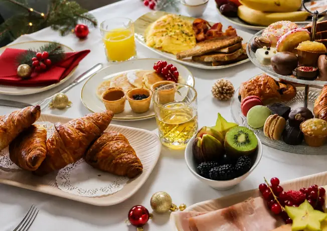 Reichhaltiger Weihnachtsbrunch mit warmen und kalten Speisen, süßen Leckereien und festlicher Weihnachtsdekoration.