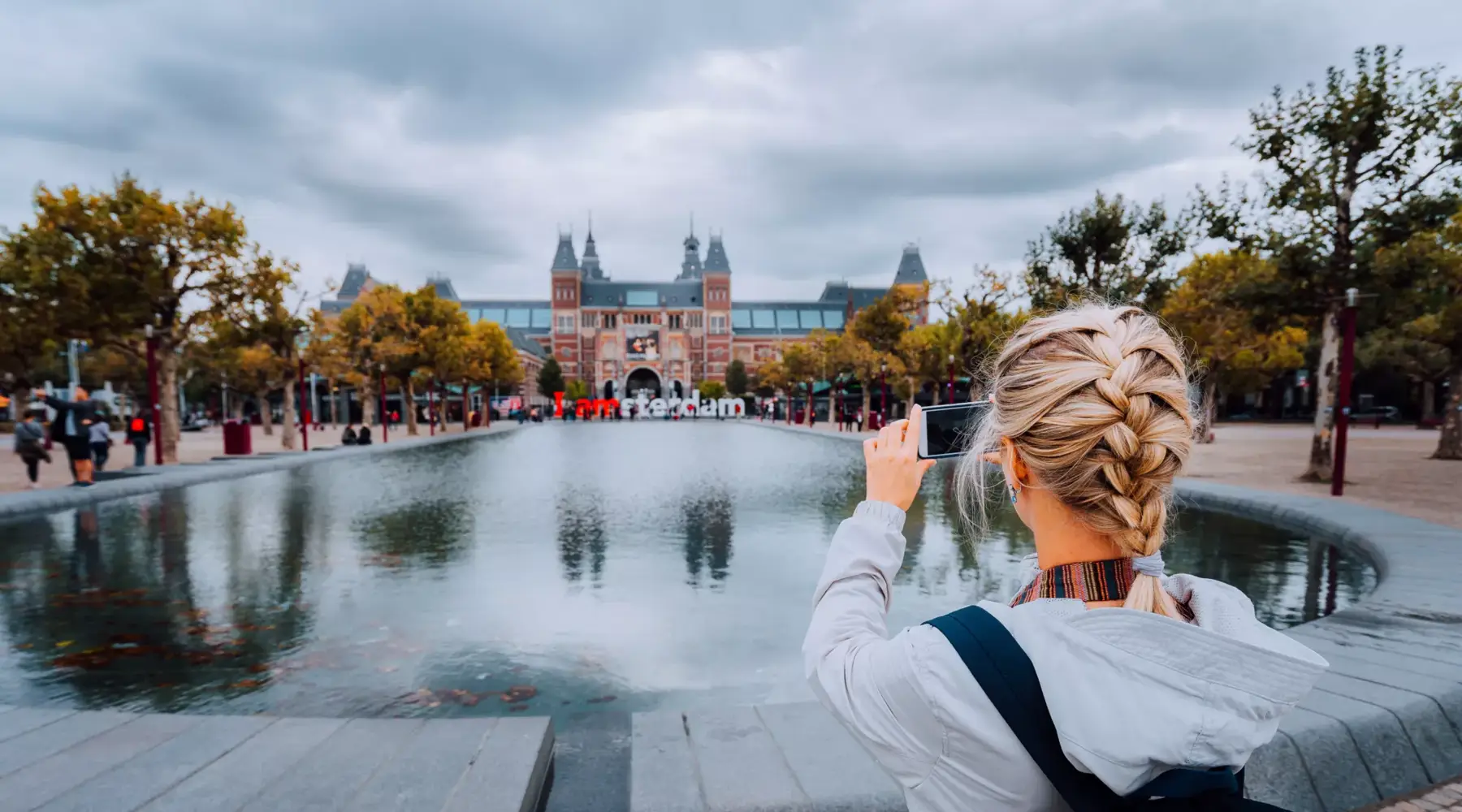 Mädchen macht ein Foto vom Rijksmuseum.