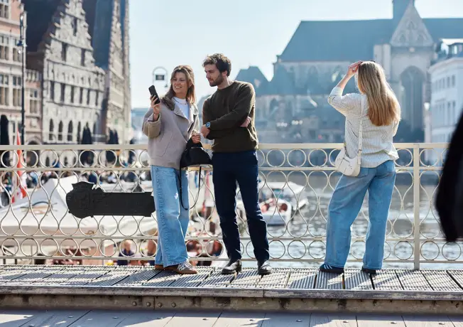 Trois personnes se promènent ensemble à travers Gand.