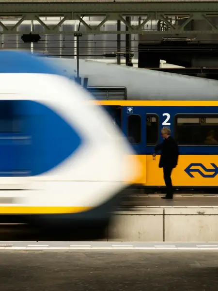 Een NS-trein vertrekt bij een treinstation