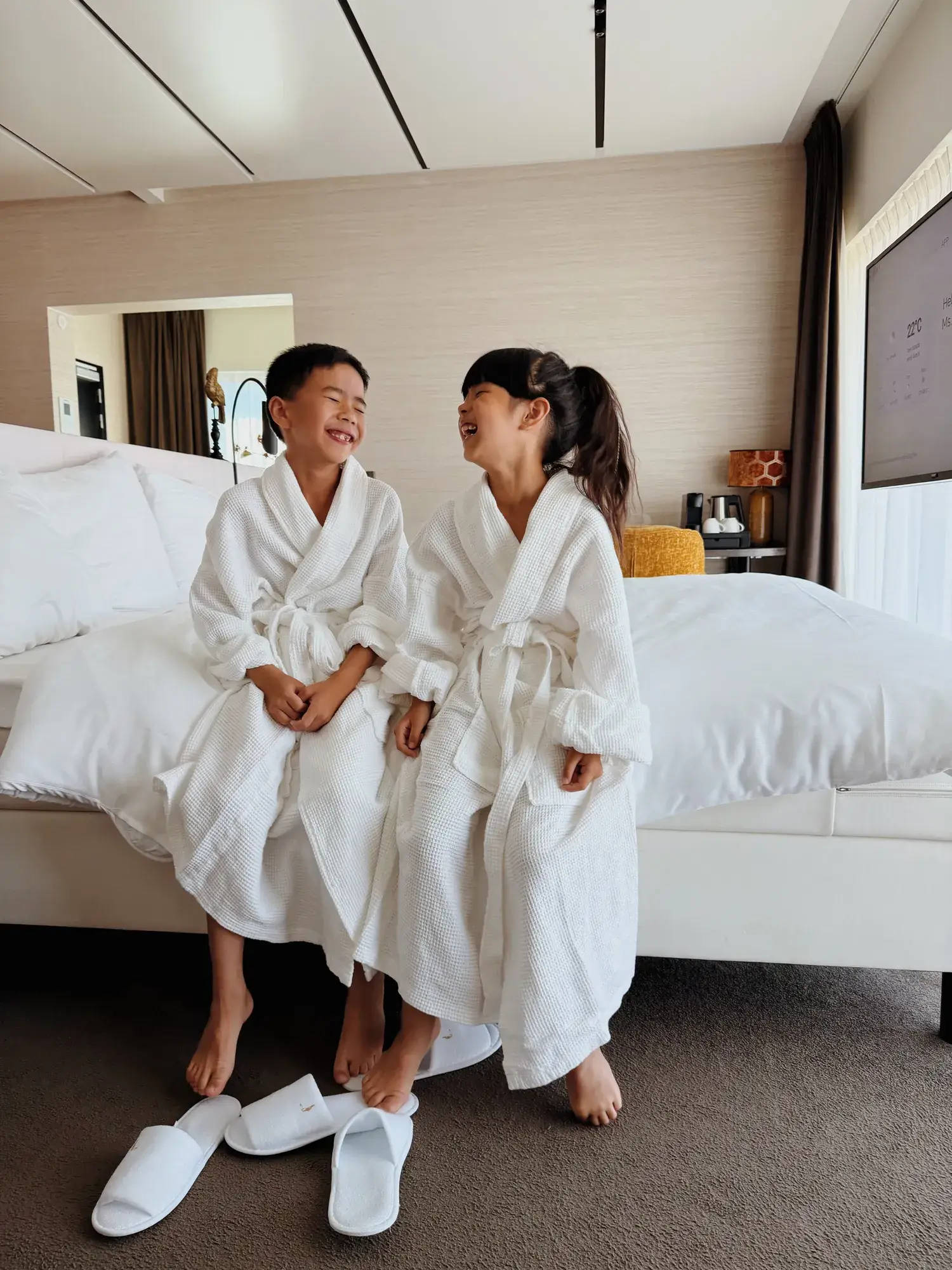 2 kinderen die op het bed zitten in de familie suite 
